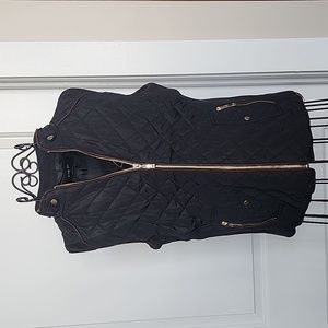 Black quilted vest with brown trim and gold zippers/buttons. Size small.